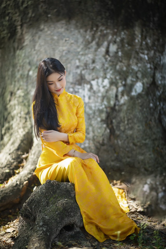 黄色いアオザイを着ているベトナム人女性